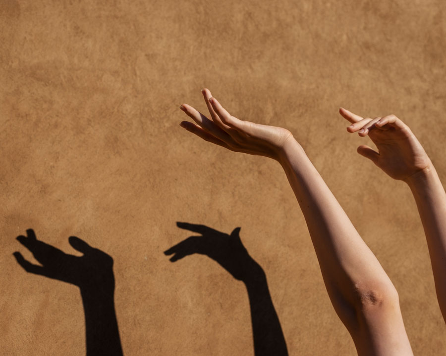 hands creating shadows on wall